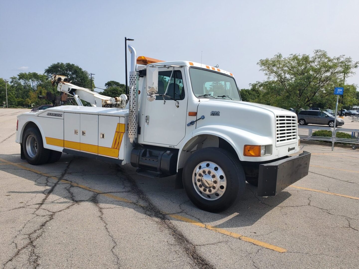 A tow truck parked in the parking lot of a building.